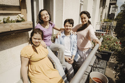 Portrait of mother with children in balcony at sunny day