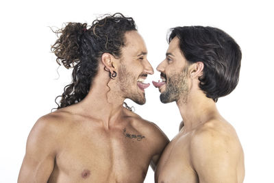 Side view of shirtless males against white background