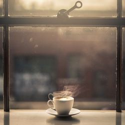 Hot coffee cup by glass window