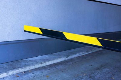 Close-up of arrow symbol on road against wall