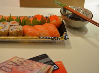 Salmon sushi in plate and paper currency on table