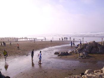 People on beach against sky