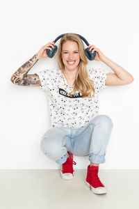 Portrait of smiling young woman against white background