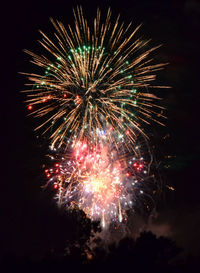 Low angle view of firework display at night