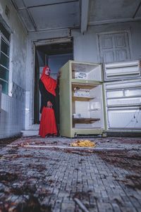 Rear view of woman standing inside the old house