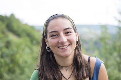 Portrait of smiling woman against sky