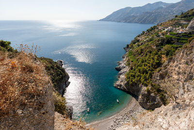 Scenic view of sea and mountains against sky