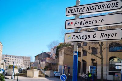 Road sign against buildings in city