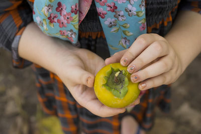 Midsection of woman holding fruit