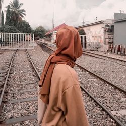 Rear view of man standing on railroad track