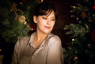 Portrait of young woman with christmas tree