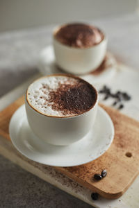 Close-up of coffee cup on cutting board