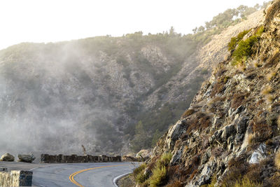 Panoramic shot of road by mountains against sky