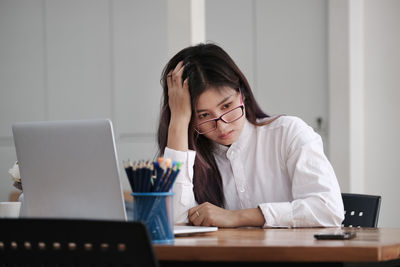 Woman using mobile phone while sitting on table