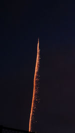 Low angle view of illuminated airplane against sky at night