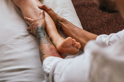 Cropped hand of man massaging women leg at spa