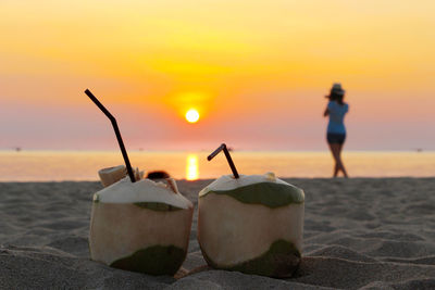 Close-up of silhouette man on beach against sky during sunset