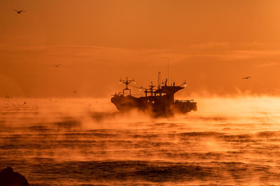 Ship on sea against sky during sunset