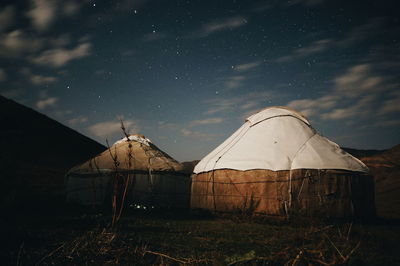 Tents on field against sky at night