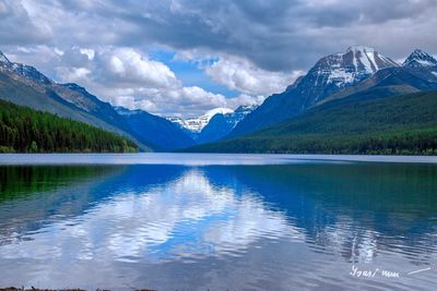 Scenic view of lake and mountains against blue sky