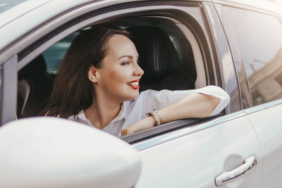 Woman looking away while sitting in car