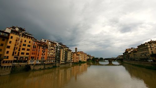 Canal amidst city against sky