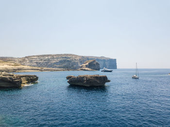 Sailboats on sea against clear sky