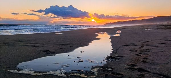 Scenic view of beach against sky during sunset