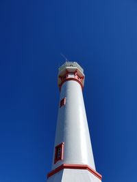 Low angle view of lighthouse against clear blue sky during sunny day