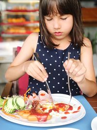 Close-up of cute girl eating breakfast at home