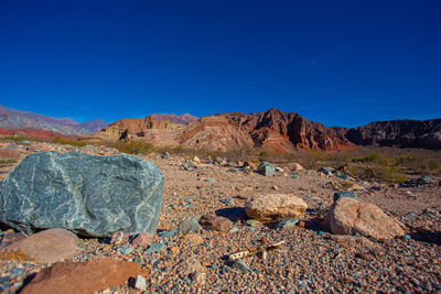 Scenic view of rock formations against blue sky