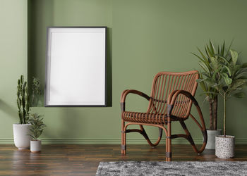 Empty vertical picture frame on green wall in modern room. mock up interior