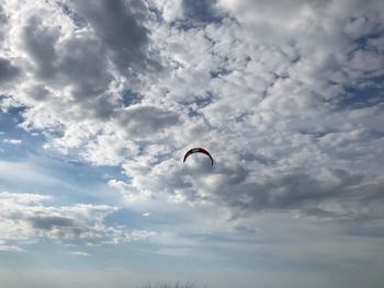 Low angle view of person paragliding against sky