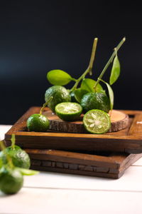 Close-up of fruits on table against black background