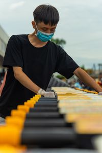 Man holding shopping carts against sky
