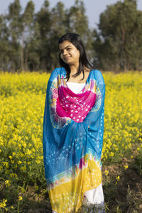 Portrait of smiling woman standing on field