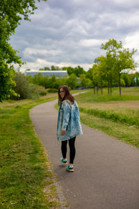 Woman walking on road against sky