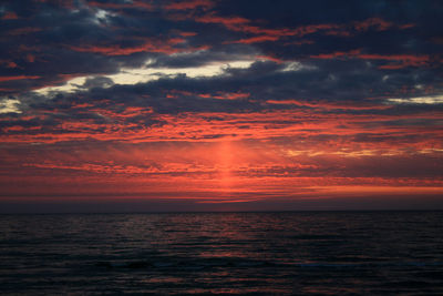 Scenic view of sea against dramatic sky during sunset