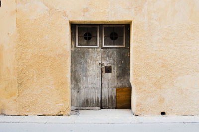 Ancient wooden door on yellow wall in marsala trapani sicily italy