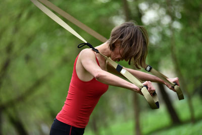 Mid adult woman exercising at public park