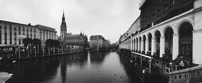 Panoramic shot of rathaus by river against clear sky