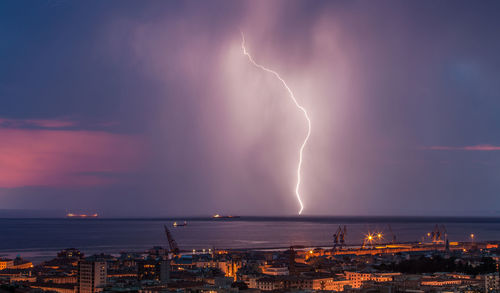 Panoramic view of lightning over city at night