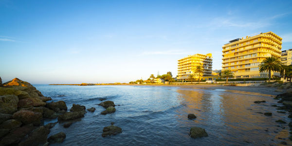 Panoramic view of sea and buildings against sky