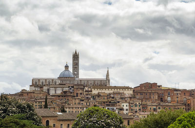 Buildings against cloudy sky