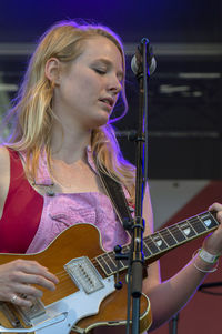 Portrait of a young woman playing guitar