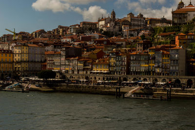 River by townscape against sky