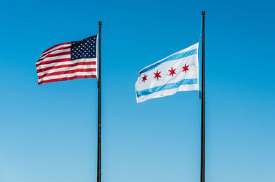 Low angle view of flag against clear blue sky