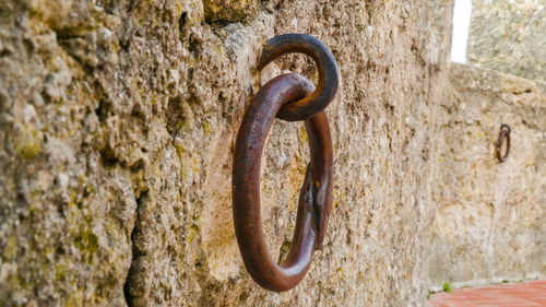 Close-up of rusty metal chain against wall