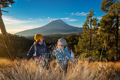 Smiling friends against landscape