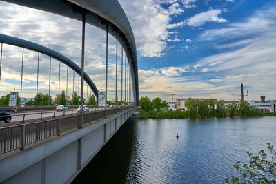 Bridge over river in city against sky